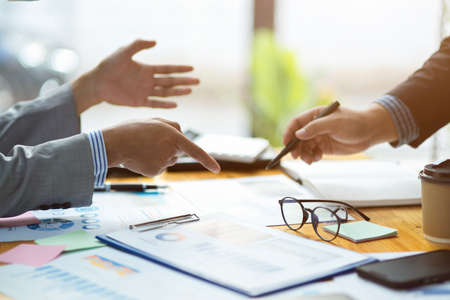 Cropped image and focus hands of a businesspeople working on financial report together on the desk.