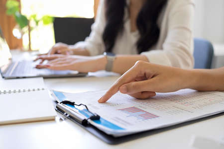 Cropped shot of a business team working and brainstorming their financial project together.の写真素材