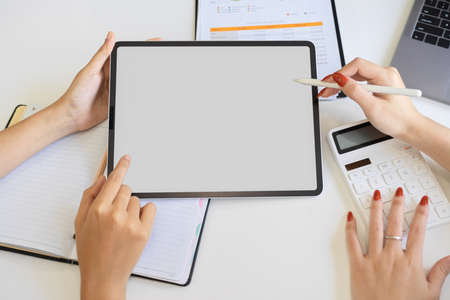 Business team using and looking at tablet touchpad computer on the office desk. tablet blank screen mockup. closeupの写真素材