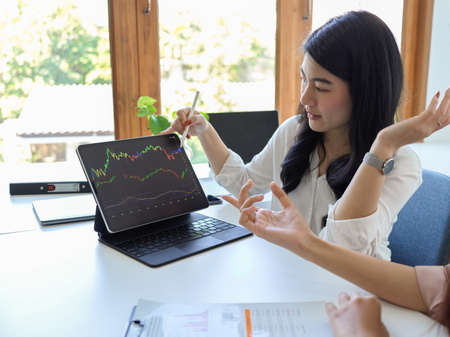 Female financial analysts analysing stock market graph and planning a financial plan to their business.の写真素材