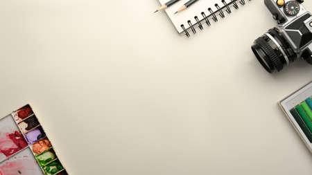 Creative workspace with a camera, a watercolour palette, a sketchbook and a copy space on white background. Designer workspace. top viewの写真素材