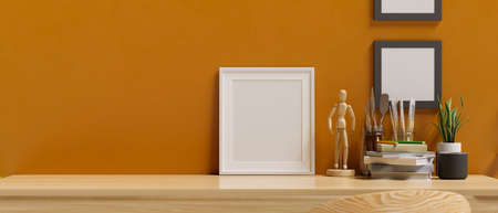 Close-up, Wooden table top with blank picture frame mockup and home decorations over modern stylish orange wall. 3d rendering, 3d illustrationの写真素材