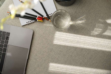 Close-up, top view of a cozy bright workspace with laptop computer, stationery, decor and copy space on tableの写真素材