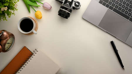 Top view, Workspace background concept with laptop, camera, supplies and copy space on white table.の写真素材