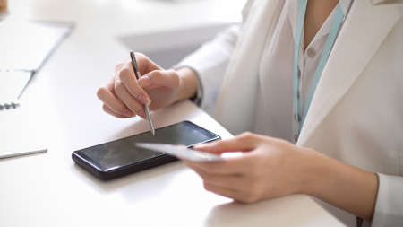 A close-up image of a successful businesswoman connecting her credit card with a mobile payment application. online payment conceptの写真素材