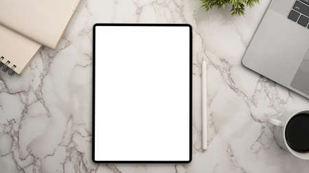 Digital tablet computer white screen mockup on marble worktable background. top viewの写真素材