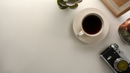Minimalist working table with copy space on white background, coffee cup, camera and decor on table.の写真素材