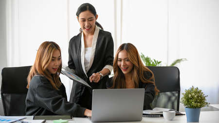 A group of marketing team working together, analysing marketing data and looking at laptop screen.の写真素材