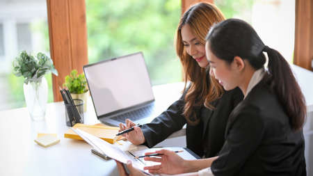 A professional marketing female manager checking her employee's work at her modern office workplace.の写真素材