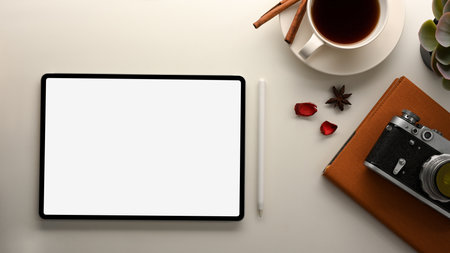 Top view of a modern workspace with a digital tablet computer with a white display to present your graphics.の写真素材