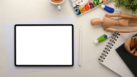 Artist workspace. Digital tablet touchpad white screen mockup and painting tools on white table.