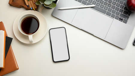 Modern business workspace with office supplies and smartphone blank screen mockup. top viewの写真素材