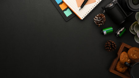 A copy space on modern black background with photographer work supplies. camera, colour checker,...