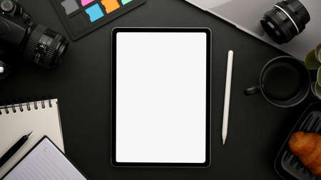 Modern creative workspace with freelance photographer's work tools, stationery and digital tablet white screen mockup. Top viewの写真素材