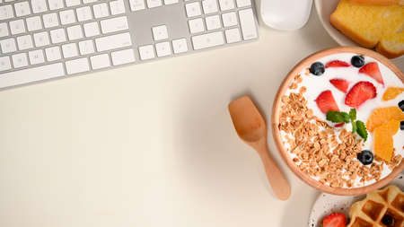 Healthy and diet breakfast concept, Yoghurt bowl with fresh berries on office worktable. flat layの写真素材