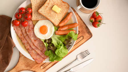 English breakfast set with egg, bacon, sausages, toasts and salad served with black coffee.の写真素材