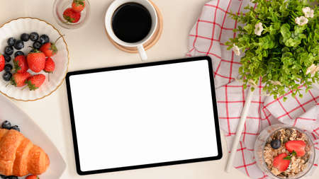 A mockup screen of digital tablet computer with healthy snacks, pastries and drink on table. template for your menu or recipe. flat layの写真素材
