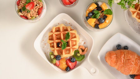 Yummy pastries concept, Waffle with fresh fruits, croissant and yoghurt bowl with berries on table.の写真素材