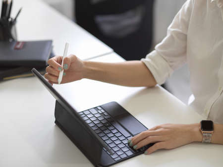 Close-up, A female using digital tablet computer with stylus pen at her modern office desk.