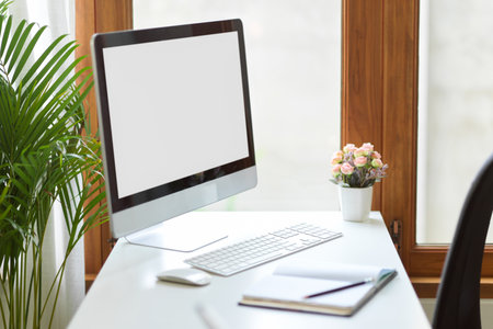 Simple office workstation with pc desktop computer and office supplies on table near the window. close-upの写真素材