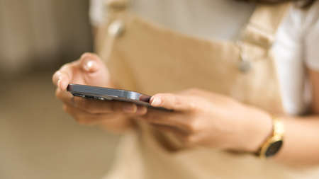 Close-up image of a young girl using modern smartphone. social media, browse internet, message, applicationの写真素材