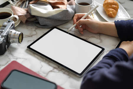 Close-up, a female freelance blogger using digital tablet computer at the cafe. tablet blank screenの写真素材