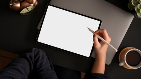 Cropped shot, overhead view of a female using stylus pen with digital tablet computer on a workspaceの写真素材