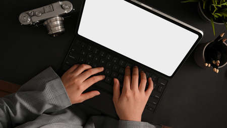 Top view of a female freelance photographer working on her portable tablet computer at her desk.の写真素材