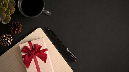 Overhead shot, a modern workspace black background with coffee cup, present box and copy space.の写真素材