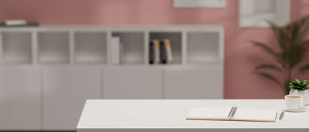 Modern stylish pink office workspace interior with copy space on white worktable over blurred office background. 3d rendering, 3d illustrationの写真素材