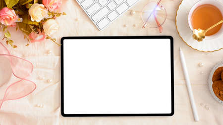 Feminine workspace with copy space on digital tablet touchpad screen. Women's office desk with beautiful decor. top viewの写真素材