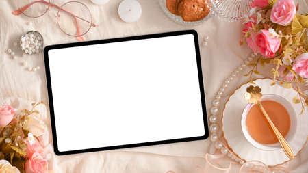 Digital tablet computer white screen mockup on beautiful elegance feminine workspace. top viewの写真素材