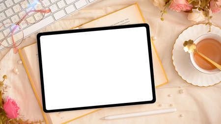 Elegance female workspace compositions with digital tablet computer blank screen mockup, tea cup and accessories. top viewの写真素材