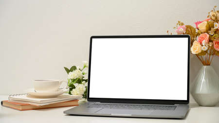 Close-up, a women's office desk with modern laptop computer white screen mockup and accessories.の写真素材
