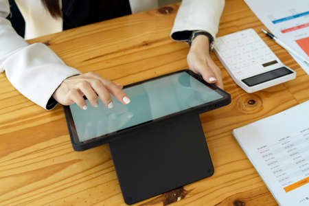 Top view, A female accountant using portable wireless tablet computer at her workspace in the officeの写真素材