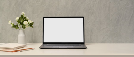 Simple minimal workspace with laptop blank screen mockup, accessories and copy space over loft wall.の写真素材