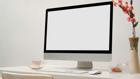 Close-up image, Modern office desk with pc desktop computer blank screen mockup and accessories on table in white office room.の写真素材