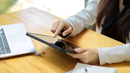 Close-up, Female touching on tablet screen, tapping her finger on screen, using digital touchpad.