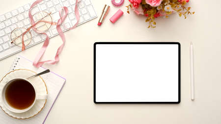 Stylish feminine workspace with digital tablet computer white screen mockup, teacup, keyboard, pink...