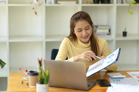 Friendly asian businesswoman showing the financial data graph and chart on the report to her online team in the online meeting.の写真素材