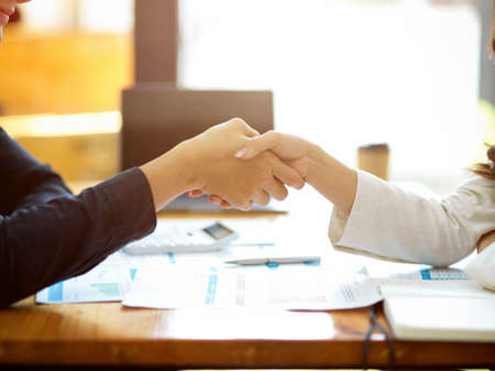Two successful and professional businesswomen are shaking hands over office desk. Business partnership, Agreement, Close the deal. cropped shotの写真素材