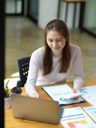 Portrait, An Asian young businesswoman or accountant is working on her assignment in the modern office.の写真素材