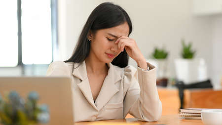 Asian Female or businesswoman crying over her failure and unsuccessful business project in the office. upset and stressed womanの写真素材