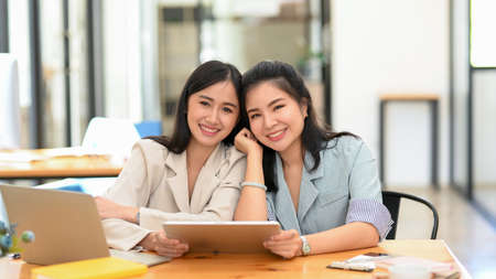 Portrait, Charming and beautiful asian young businesswomen, company worker or employee sits in the modern office. happy colleague, cheerful coworker.の写真素材