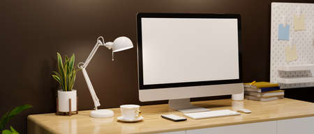 Modern contemporary workstation with pc desktop computer blank screen mockup, table lamp and accessories on wooden table over brown wall. 3d rendering, 3d illustrationの写真素材