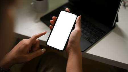 Close-up, A female using smartphone over her office desk. smartphone white screen. Chat, Message, Text, Social media, Internetの写真素材