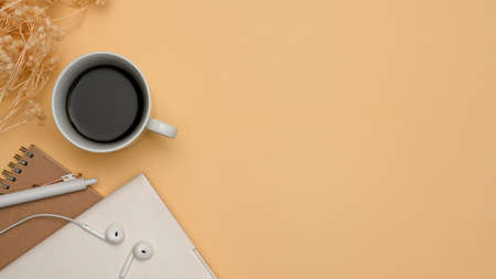 Modern cozy minimal office desk table workspace with black coffee cup, notebooks, pen, earphone,...