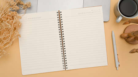 Office workspace in beige background top view with office supplies and empty notebook pages for display your text.の写真素材