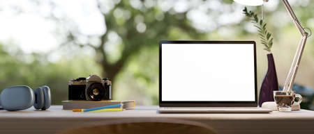 Close-up, Home office workspace tabletop with laptop computer blank screen mockup and accessories on table over blurred outdoor view in the background. 3d rendering, 3d illustrationの写真素材