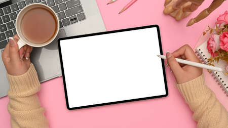 Female beauty blogger workspace, A female sketching something on her digital tablet while sipping...